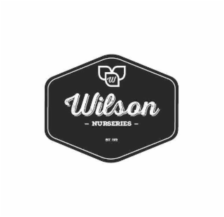 A 6-SIDED POLYGON SHAPE WITH A LOGO HAVING 3 LEAVES WITH 1 LETTER W IN 1 LEAF AND THE WORDS WILSON NURSERIES BELOW THE LOGO.